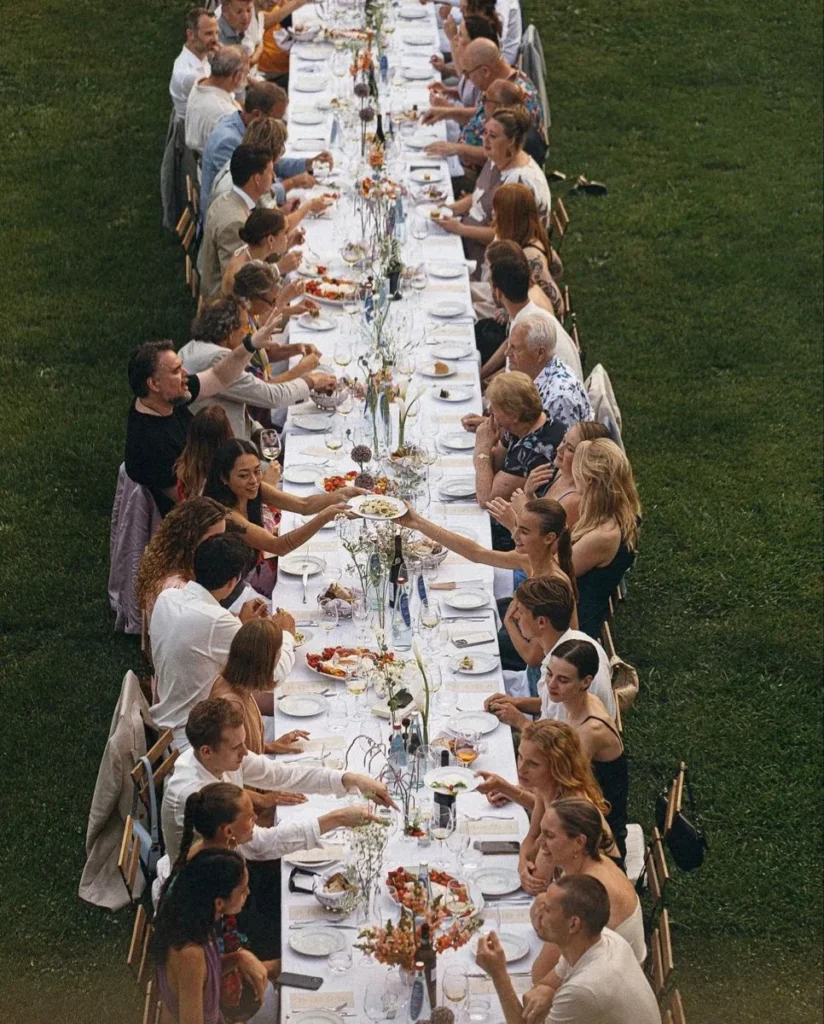 A long shared table of guests on the lawn