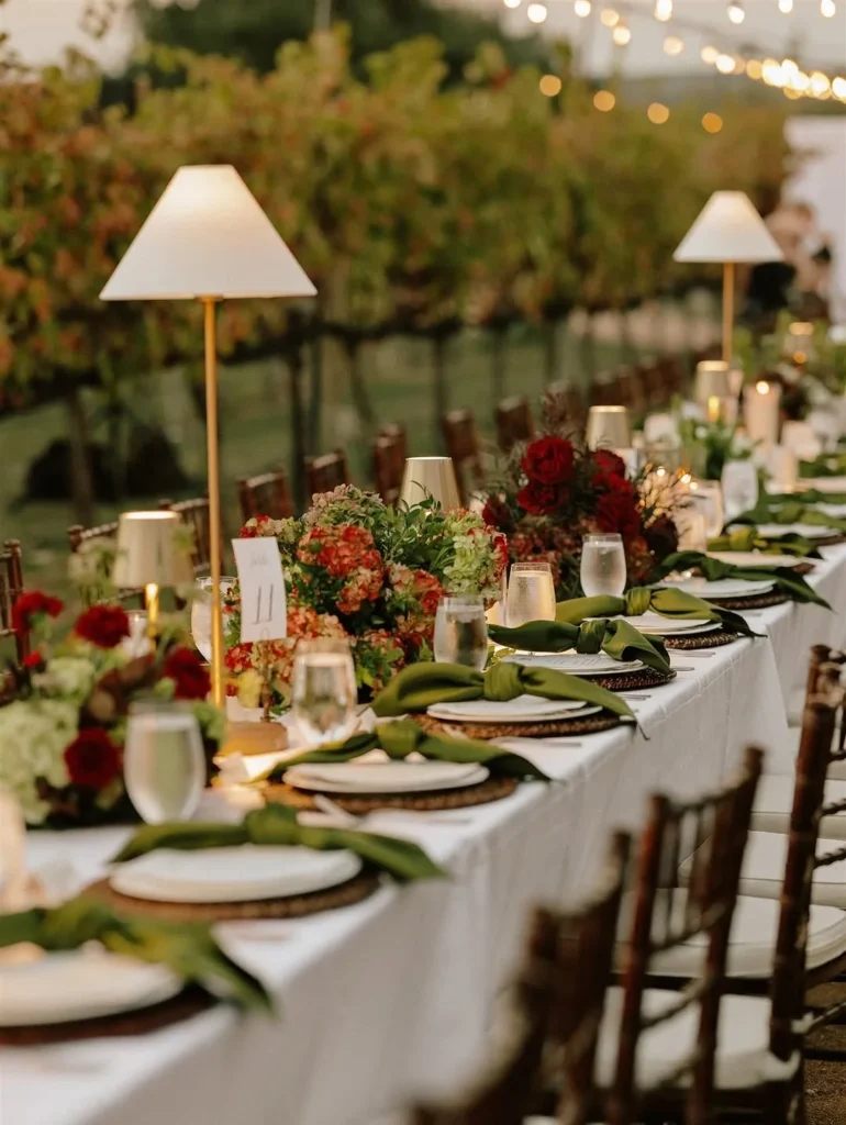 A wedding table with flowers and lamps beside the vines